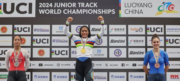 tefany Cuadrado levantando el trofeo y mostrando su medalla de oro tras ganar la prueba del keirin en Luoyang, China.