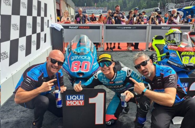 David Alonso celebrando su victoria en el GP de Austria 2024, levantando su trofeo en el podio mientras suena el himno de Colombia.