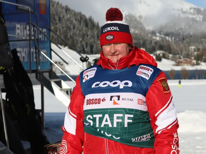 Atleta de biatlón ruso compitiendo en un evento de invierno, con un paisaje montañoso de fondo.